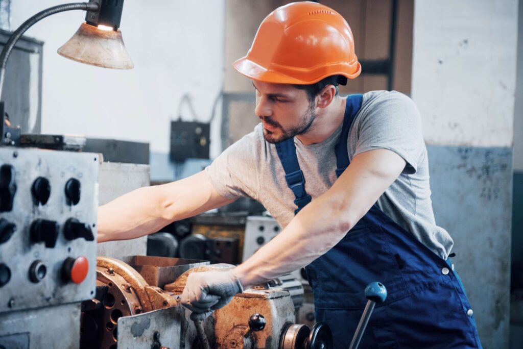 A man wearing a helmet works in a factory
