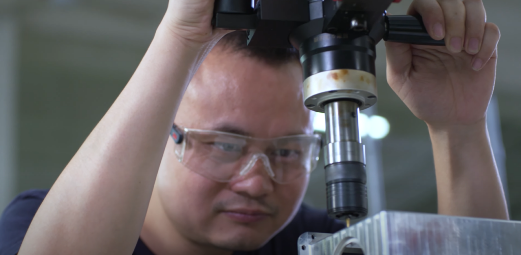 man wearing protective glasses operating a machine