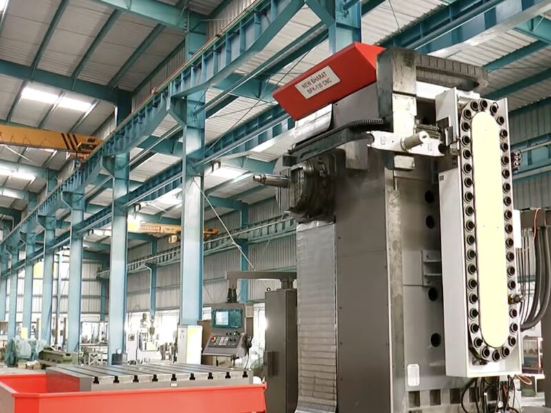 A wide-angle view of a large industrial hall featuring a floor type boring machine with a red and white upper housing